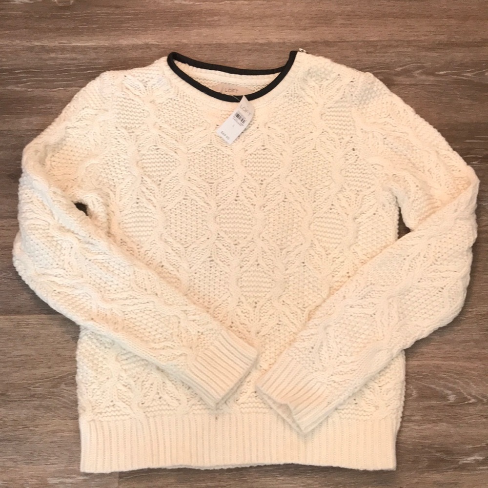 knit sweater with faux leather accent around neck.